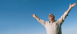 An old man raising his hands towards the sky