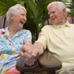 Older couple smiling and holding hands