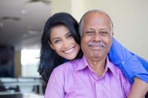 An old father with his daughter standing at back and smiling