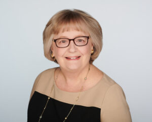 An old smiling woman with short hair and beautiful dress