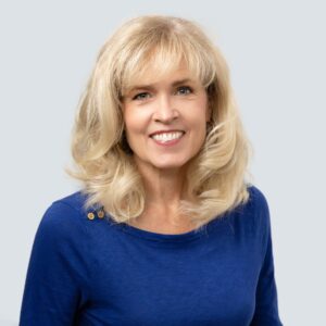 A Portrait of a Woman in Blue SHirt and Blond Hair